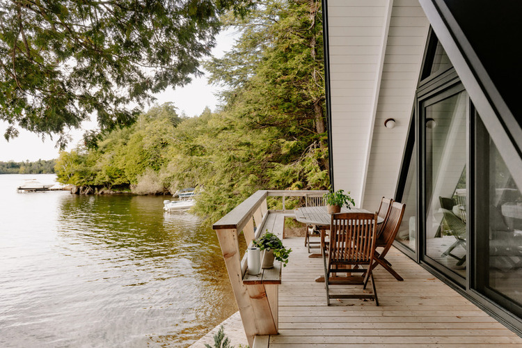 Udobna terasa vikendice A-okvira nudi savršen pogled na okolno jezero